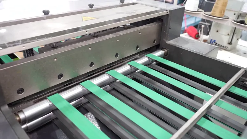 Paper materials pass through rollers and conveyor belts on processing equipment